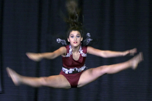 Dancer jumping into the splits on stage